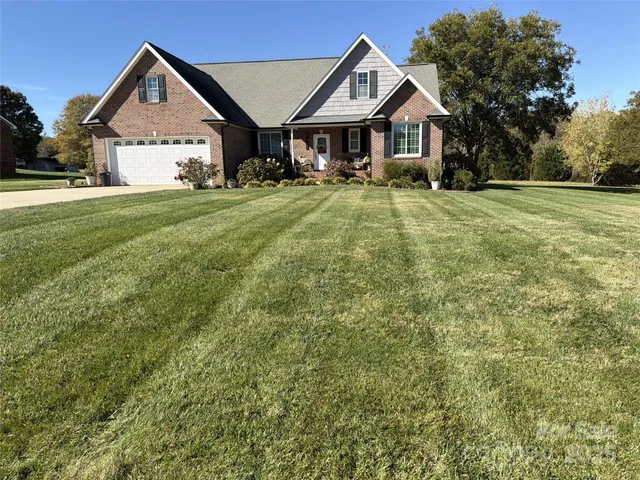 a front view of a house with a yard and trees