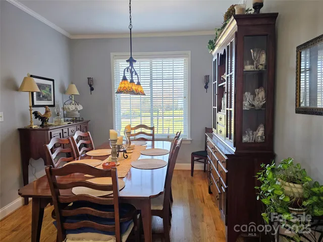 a dining room with furniture a chandelier and window