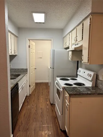 a kitchen with a stove and a wooden floors