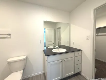 a bathroom with a toilet a sink a mirror and vanity