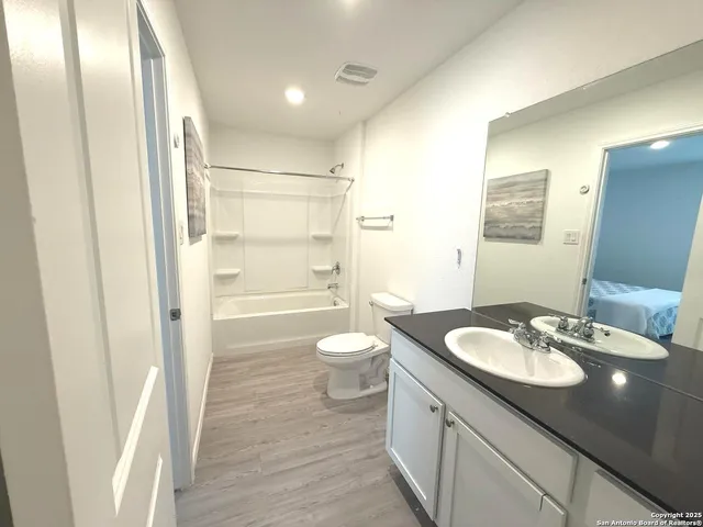 a bathroom with a granite countertop sink toilet a large mirror a shower and vanity