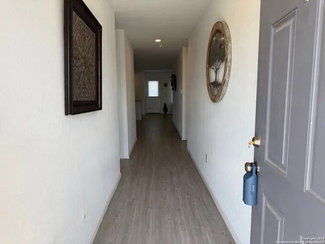 a view of a hallway with wooden floor and entryway