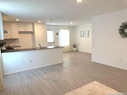 a kitchen with stainless steel appliances granite countertop a sink and cabinets with wooden floor