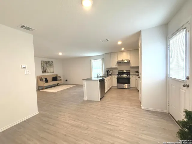 a view of kitchen with kitchen island white cabinets and refrigerator