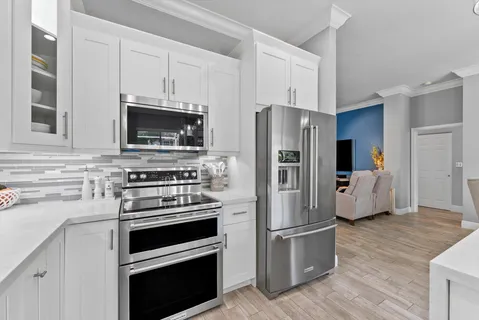 a large kitchen with kitchen island a sink stainless steel appliances and cabinets