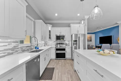 a kitchen with a stove a sink and a wooden floors