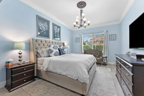 a bedroom with a bed television and a window