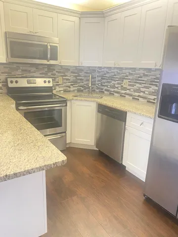 a kitchen with stainless steel appliances granite countertop a sink stove and cabinets