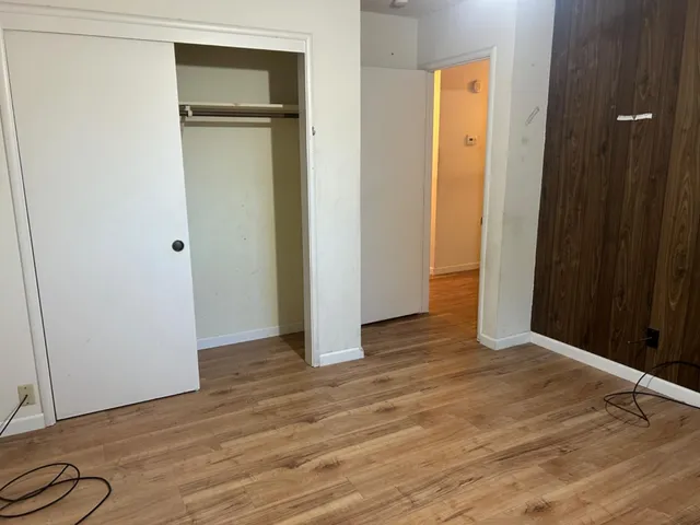 a view of an empty room with wooden floor