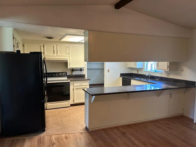 a kitchen with granite countertop a refrigerator and a sink