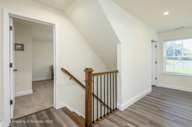 a view of a hallway with wooden floor and entryway