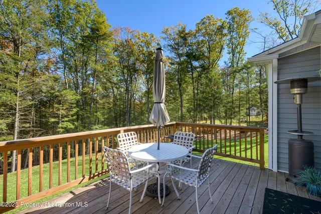 a view of a deck with a table and chairs with wooden floor and fence