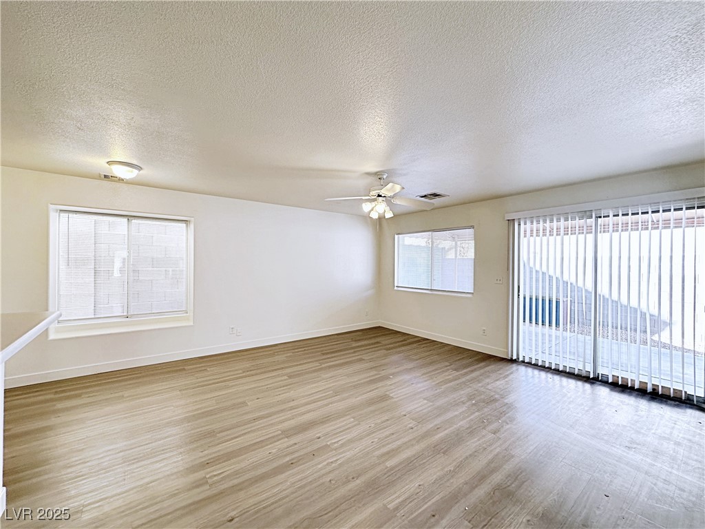 9416 Moon Splash Court Las Vegas, NV 89129 - Photo 12 of 47 Spare room with light wood finished floors, a textured ceiling, and a ceiling fan