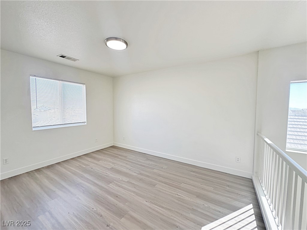 9416 Moon Splash Court Las Vegas, NV 89129 - Photo 22 of 47 Empty room with light wood-style floors and a textured ceiling