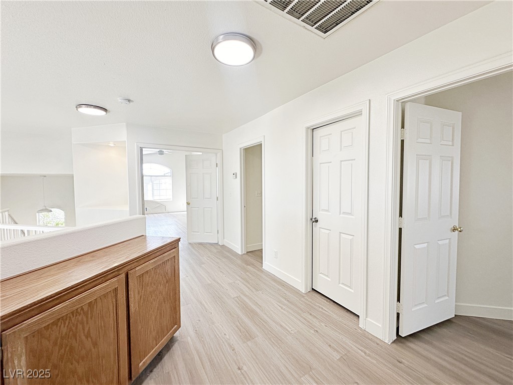 9416 Moon Splash Court Las Vegas, NV 89129 - Photo 24 of 47 Hall with light wood-style flooring and an upstairs landing