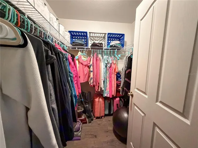 a view of walk in closet with clothes