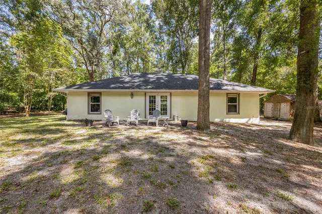 a view of a house with backyard and trees