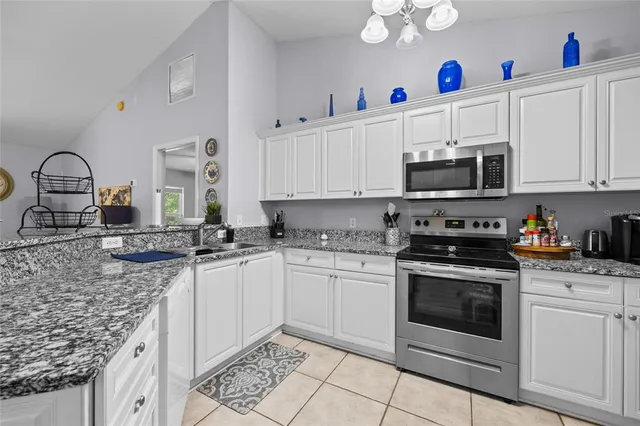 a kitchen with kitchen island granite countertop a sink stainless steel appliances and cabinets