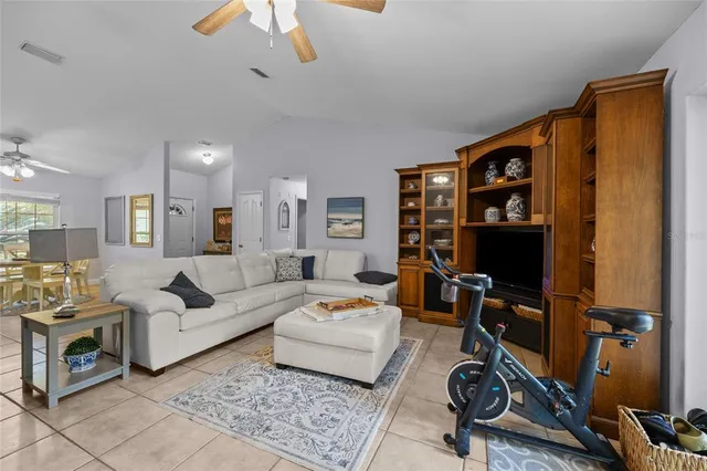 a living room with furniture a rug and gym equipment