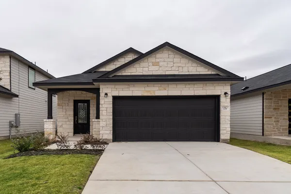 a front view of a house with a yard and garage