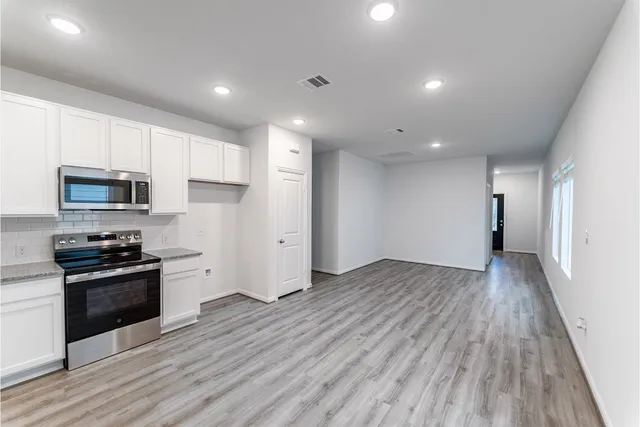a view of a kitchen with electric appliances and cabinets