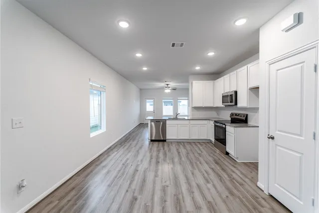 a kitchen with a refrigerator and white cabinets