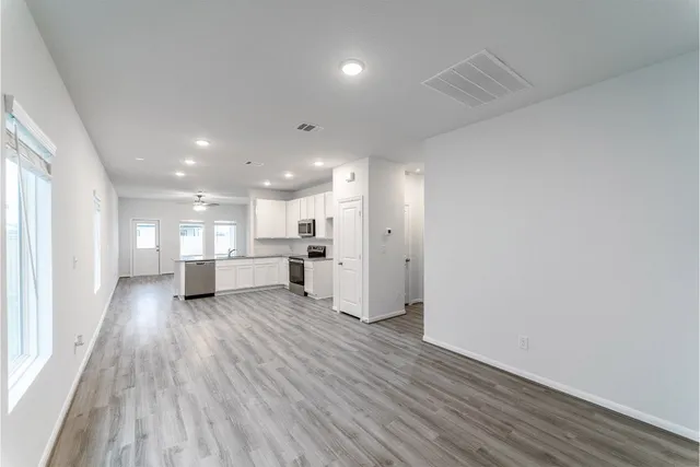 a view of an empty room with wooden floor