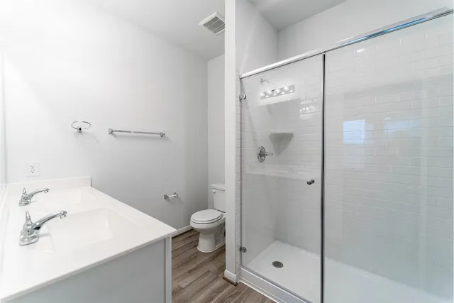 a bathroom with a shower sink vanity and toilet