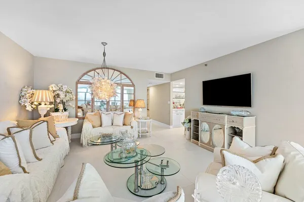 a living room with furniture a flat screen tv and a large window