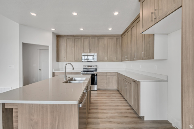 3839 West 825 North, Unit WF18 West Point, UT 84015 - Photo 7 of 22 Kitchen with recessed lighting, stainless steel appliances, an island with sink, light wood-style flooring, and light stone countertops