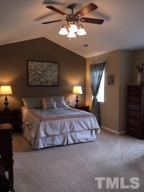 8305 Rubblestone Path Raleigh, NC 27613 - Photo 17 of 24 a spacious bedroom with a bed and a chandelier