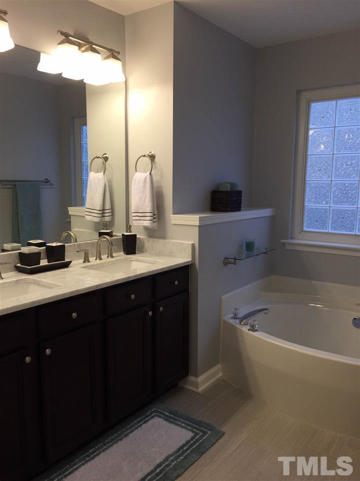 8305 Rubblestone Path Raleigh, NC 27613 - Photo 19 of 24 a bathroom with a tub sink and mirror