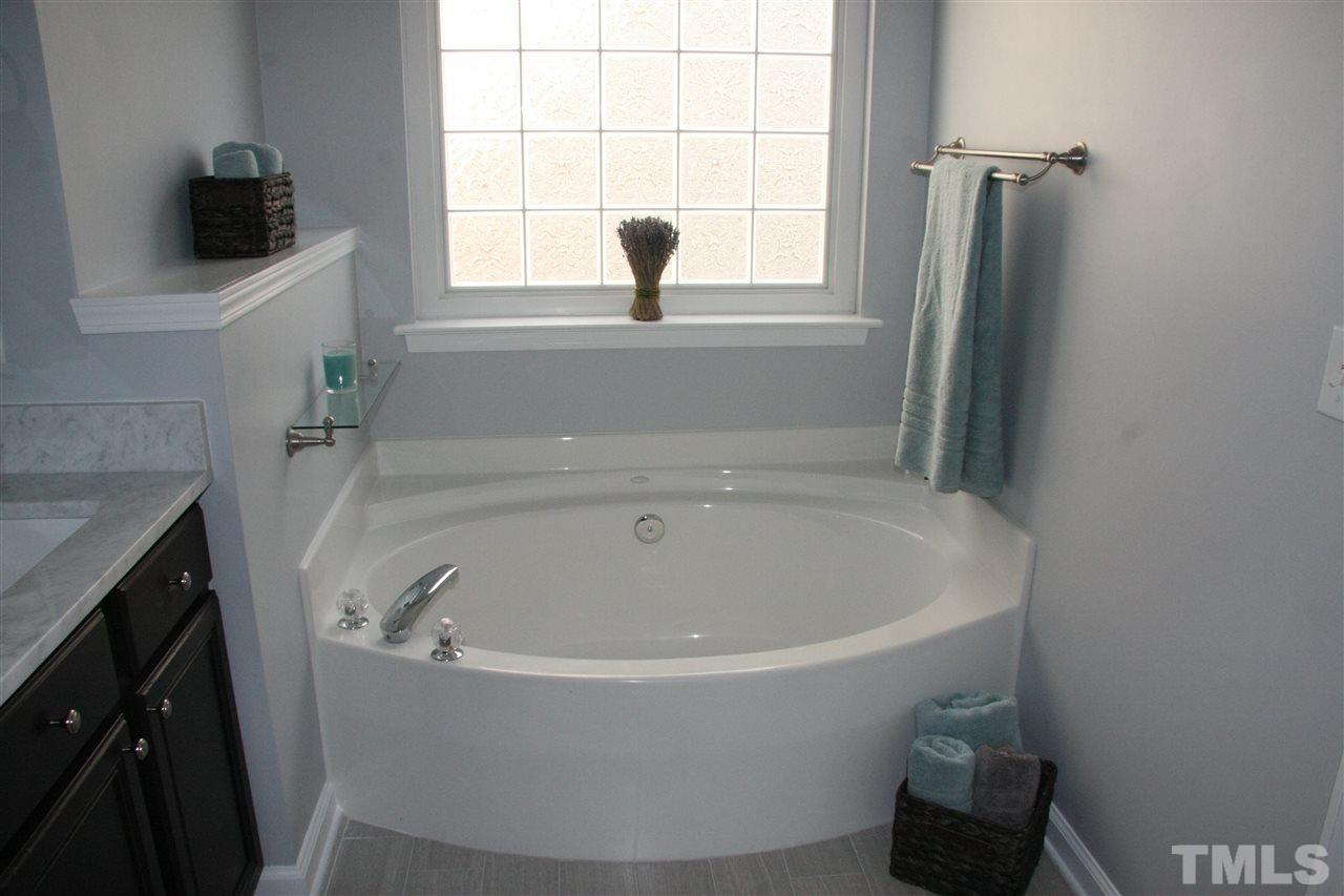 8305 Rubblestone Path Raleigh, NC 27613 - Photo 20 of 24 a white bath tub sitting in a bathroom