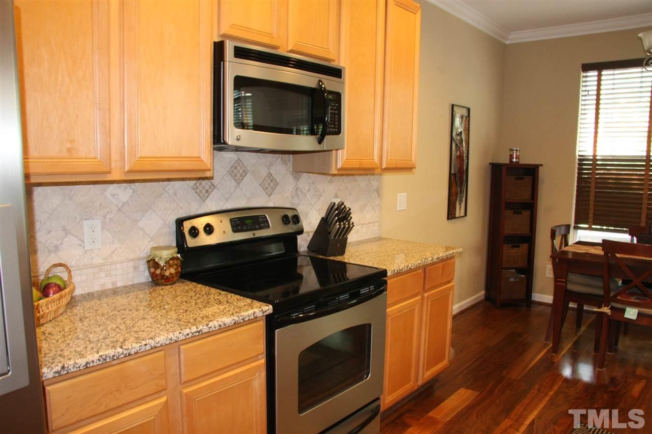 8305 Rubblestone Path Raleigh, NC 27613 - Photo 6 of 24 a kitchen with stainless steel appliances granite countertop a stove a sink and a microwave