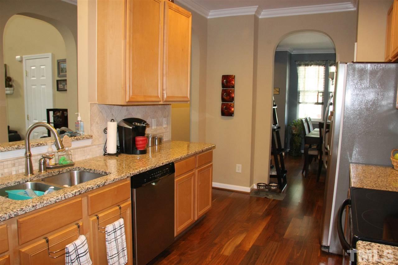 8305 Rubblestone Path Raleigh, NC 27613 - Photo 7 of 24 a kitchen with a sink a refrigerator and cabinets