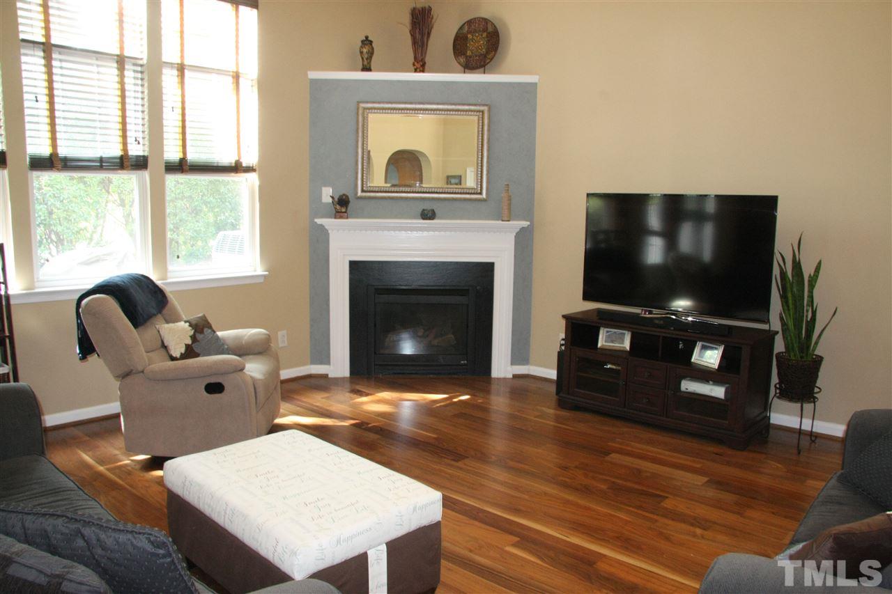 8305 Rubblestone Path Raleigh, NC 27613 - Photo 10 of 24 a living room with furniture a fireplace and a flat screen tv