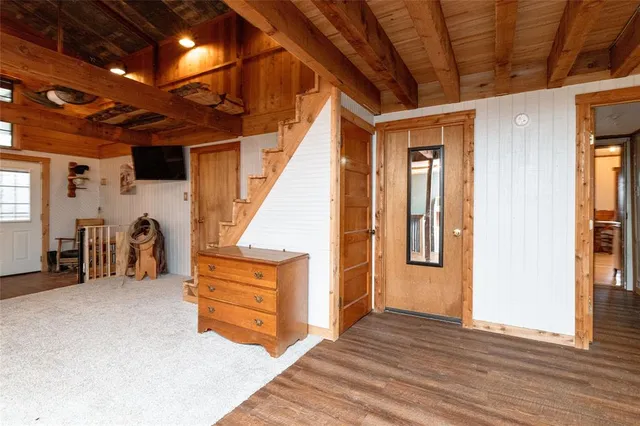 a view of an empty room with wooden floor and a ceiling fan