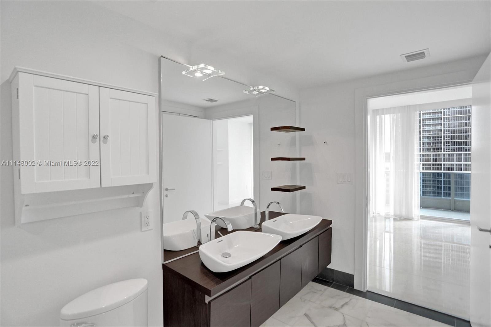 200 Biscayne Blvd Way, Unit 1403 Miami, FL 33131 - Photo 35 of 67 a bathroom with a sink a toilet and shower