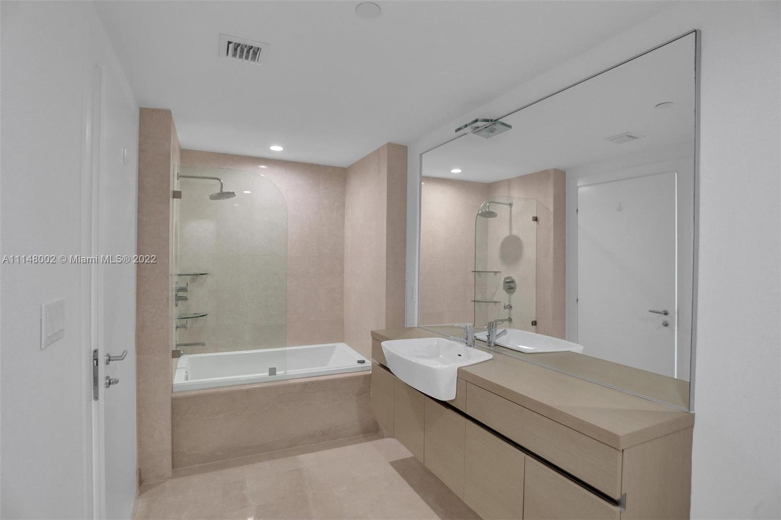 200 Biscayne Blvd Way, Unit 1403 Miami, FL 33131 - Photo 53 of 67 a bathroom with a granite countertop sink a mirror and a bathtub