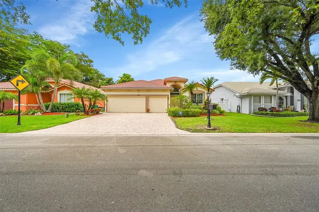 a view of a house with a backyard and a tree