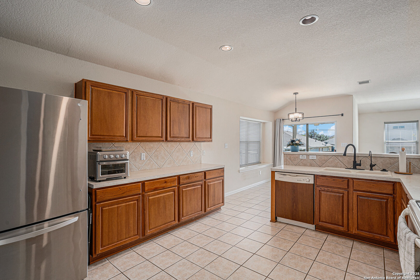 117 Hidden Fawn Cibolo, TX 78108 - Photo 8 of 25 a kitchen with stainless steel appliances granite countertop a refrigerator sink and cabinets
