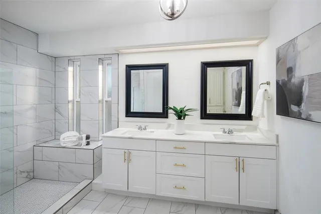 a bathroom with a double vanity sink a mirror and a shower