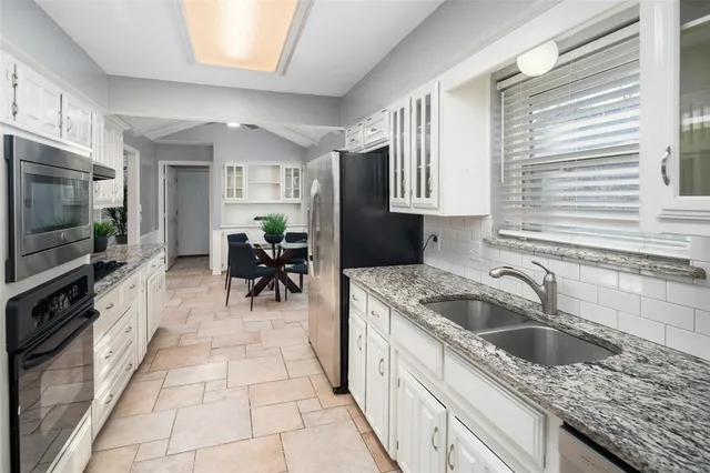 a kitchen with granite countertop a sink and a stove top oven