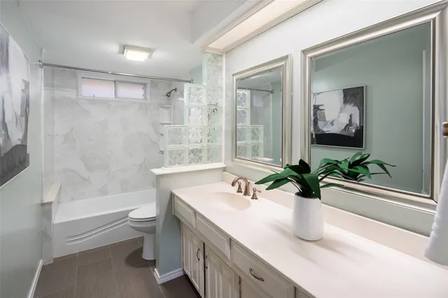 a bathroom with a sink a toilet a tub and shower