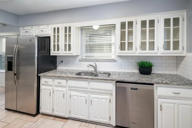 a kitchen with stainless steel appliances granite countertop white cabinets and a granite counter tops