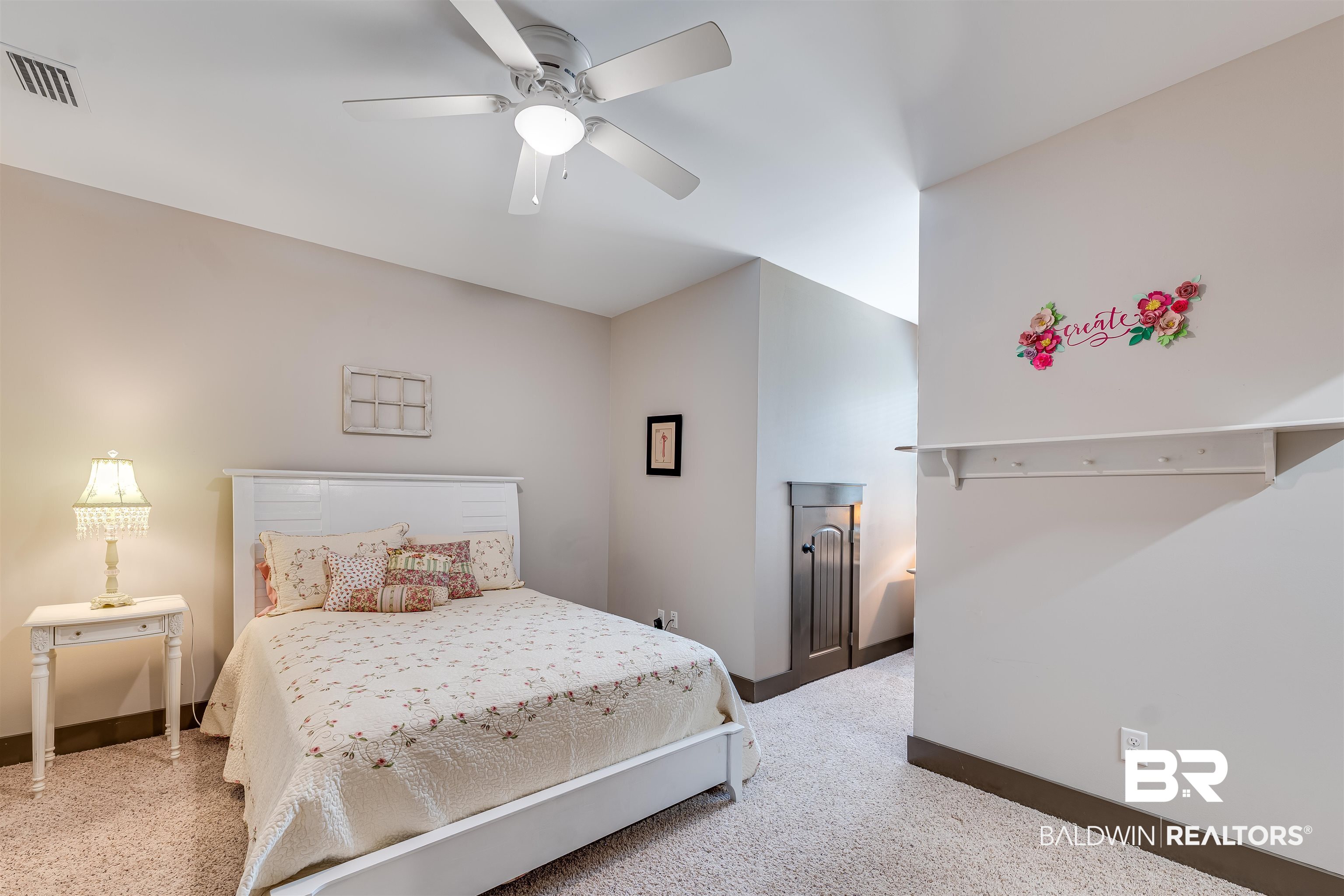1119 Pink Poppy Lane Foley, AL 36535 - Photo 32 of 38 2nd floor bedroom with walk-in in closet, light carpet, and a ceiling fan