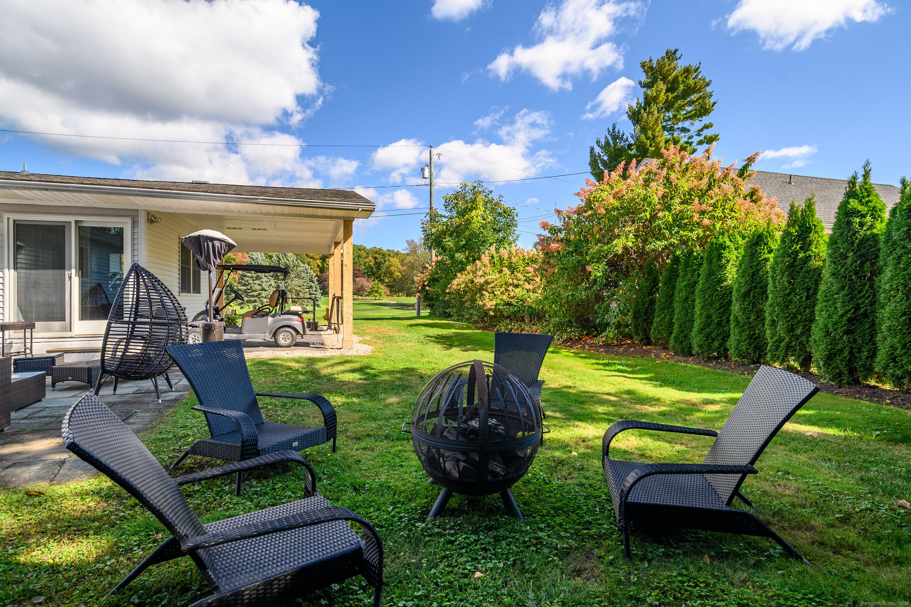 22 Brookside Trail New Milford, CT 06776 - Photo 25 of 40 a view of a backyard with table and chairs potted plants and a palm tree