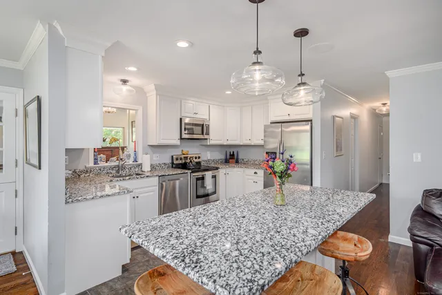 a kitchen with stainless steel appliances granite countertop a sink refrigerator and microwave