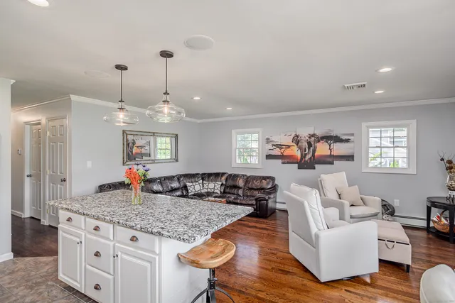 a living room with furniture kitchen view and a chandelier