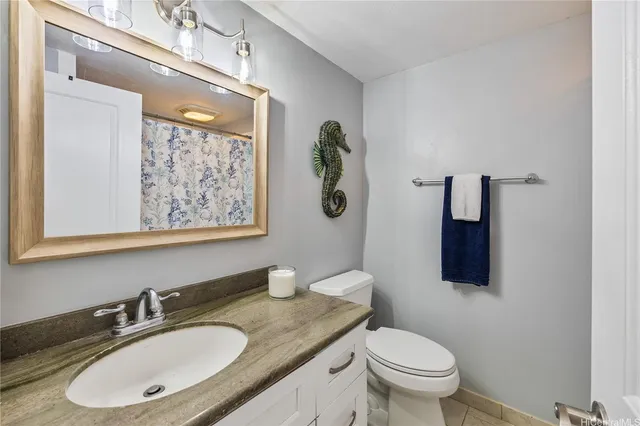 a bathroom with a granite countertop toilet sink and mirror